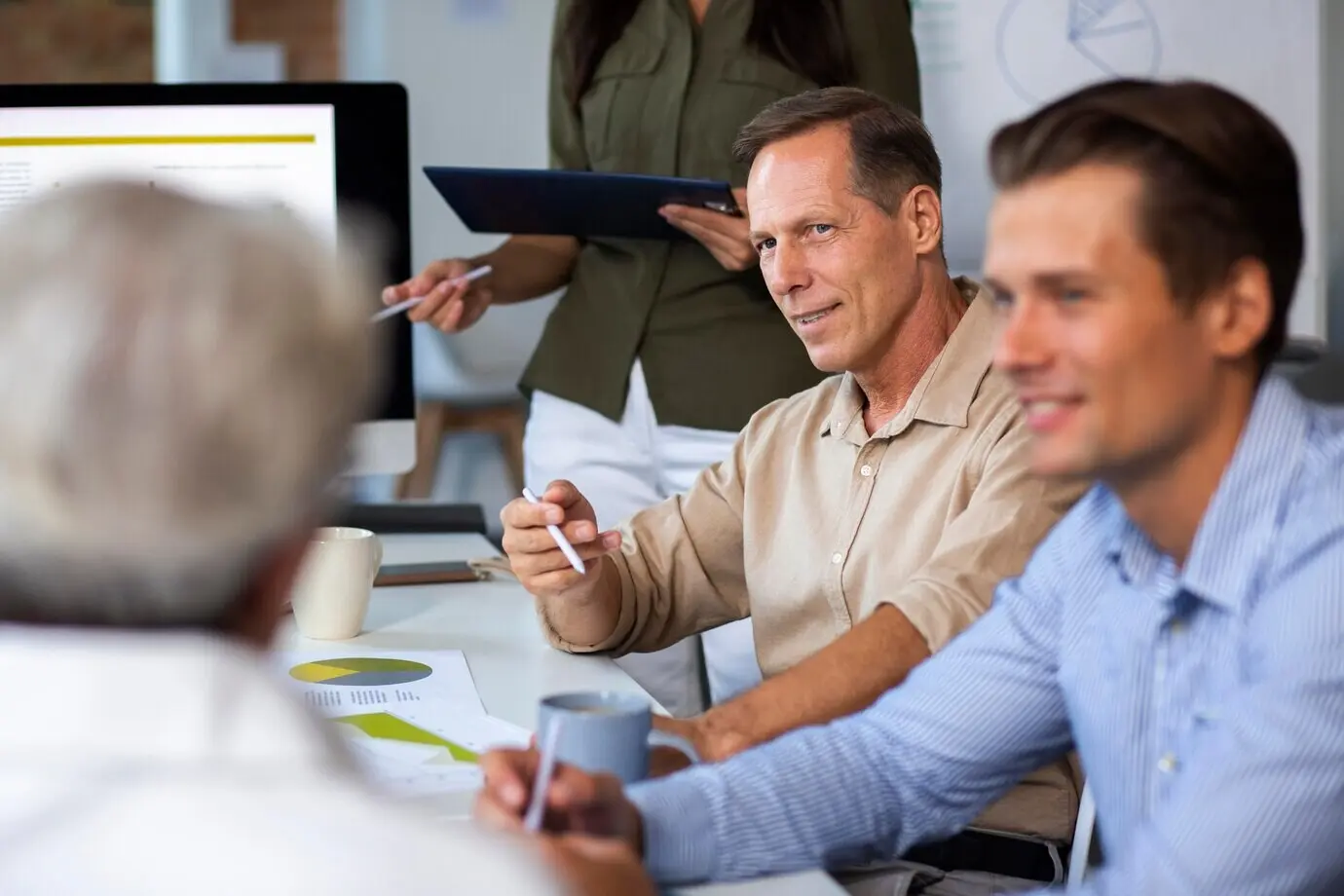 Nahaufnahme einer lächelnden Person in einem Konferenzraum.